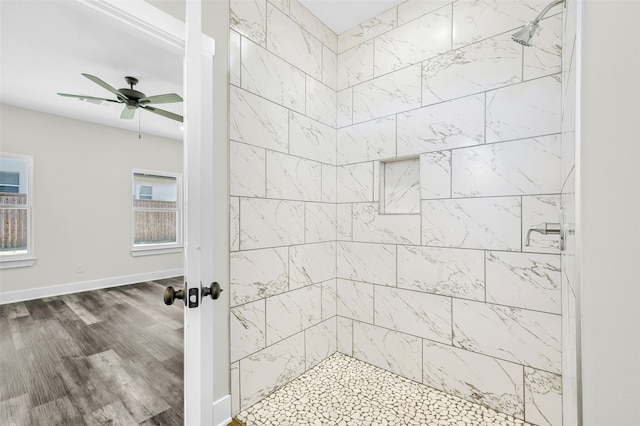 bathroom featuring a tile shower, hardwood / wood-style floors, and ceiling fan