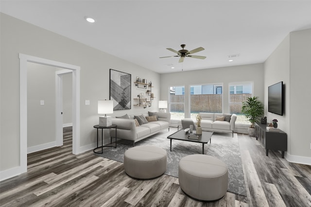 living room featuring dark wood-type flooring and ceiling fan