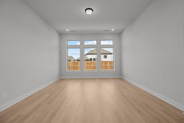 spare room featuring light wood-style flooring, baseboards, and recessed lighting