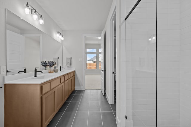 bathroom with baseboards, double vanity, a sink, and tile patterned floors