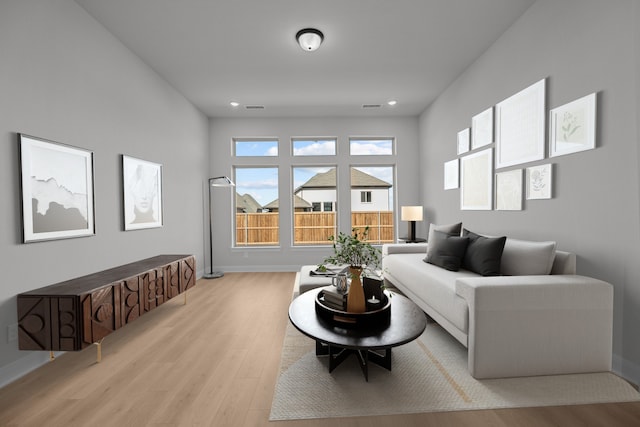 living area featuring baseboards, visible vents, and light wood-style floors