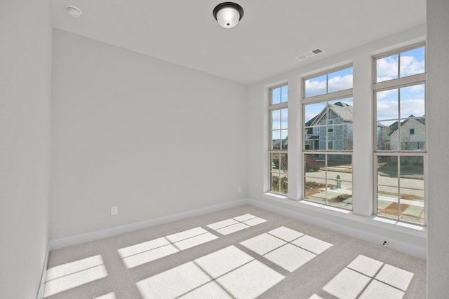 unfurnished room featuring carpet flooring, plenty of natural light, visible vents, and baseboards