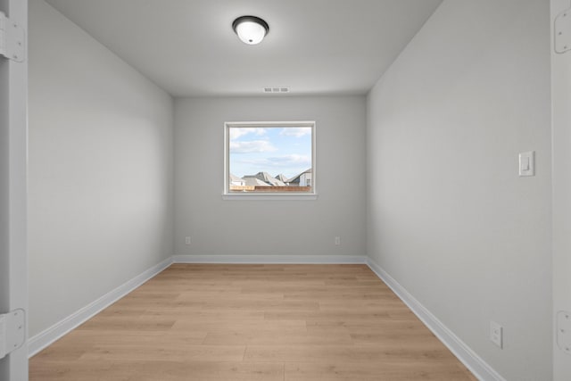 spare room with light wood-style floors, visible vents, and baseboards