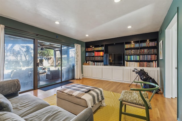 living room with built in shelves and light hardwood / wood-style floors