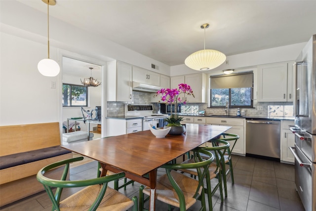 kitchen featuring stainless steel appliances, sink, white cabinets, plenty of natural light, and range hood