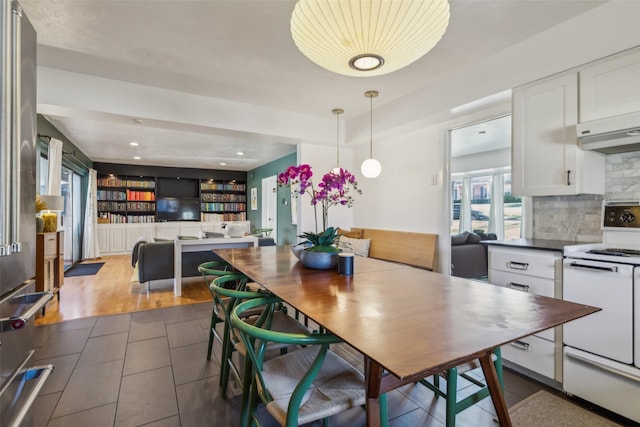 tiled dining area featuring built in shelves