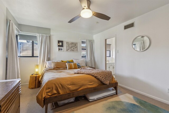 carpeted bedroom featuring ceiling fan and ensuite bath