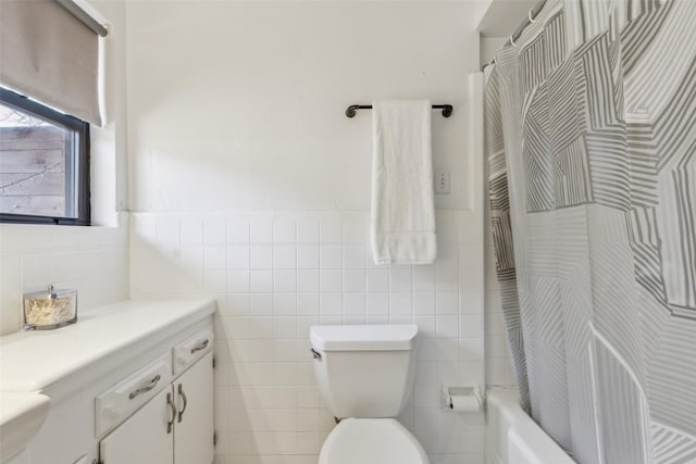 full bathroom with shower / tub combo with curtain, vanity, tile walls, and toilet