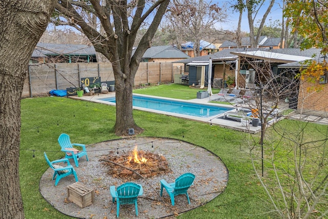 view of pool featuring a yard, a fire pit, and a patio area