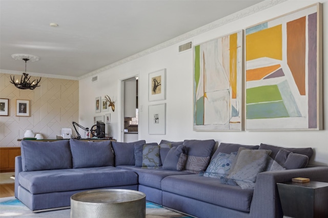 living room with crown molding and a notable chandelier