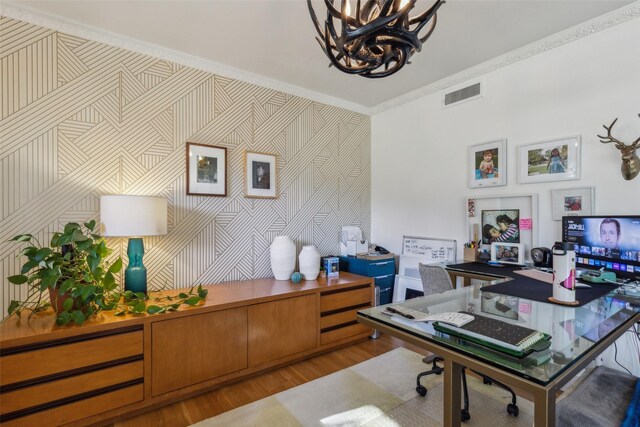 office featuring light hardwood / wood-style floors, ornamental molding, and a notable chandelier