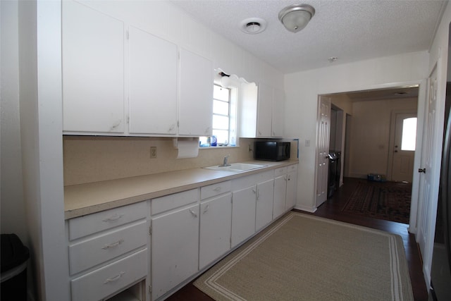 950 N Munday Ave, Munday, TX 76371 - kitchen with white cabinetry, sink, and a textured ceiling