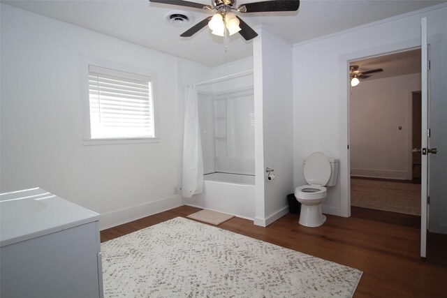 950 N Munday Ave, Munday, TX 76371 - full bathroom featuring hardwood / wood-style flooring, vanity, toilet, and shower / bath combo with shower curtain