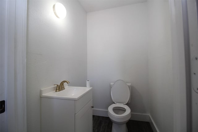 950 N Munday Ave, Munday, TX 76371 - bathroom featuring vanity, wood-type flooring, and toilet
