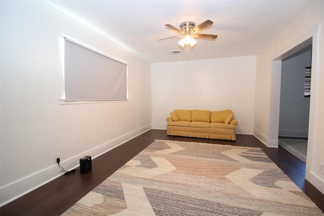 950 N Munday Ave, Munday, TX 76371 - living area featuring ceiling fan, dark wood-type flooring, and a textured ceiling