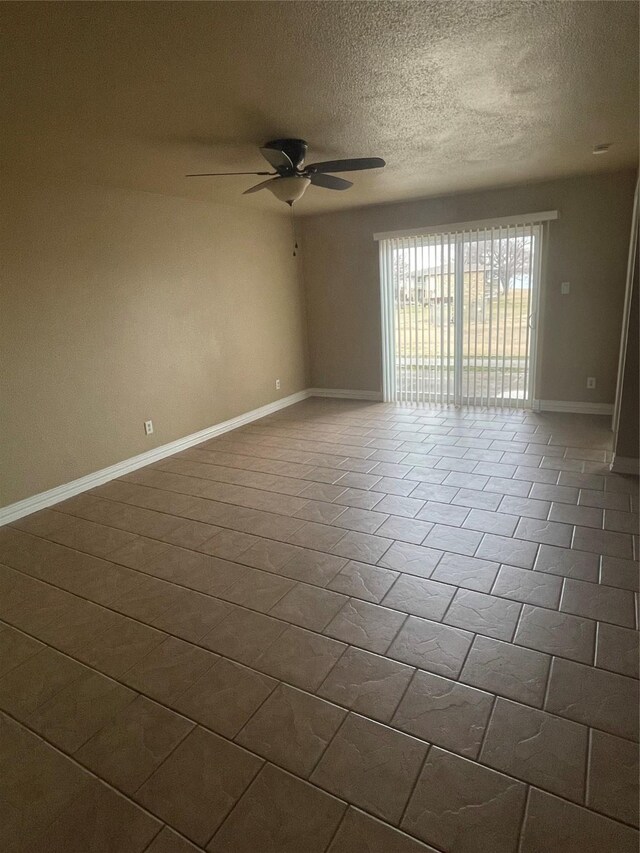 empty room with ceiling fan and a textured ceiling