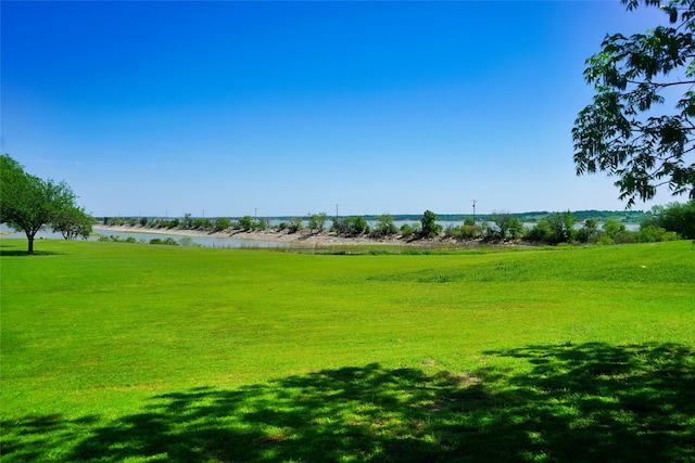 view of property's community with a water view and a yard