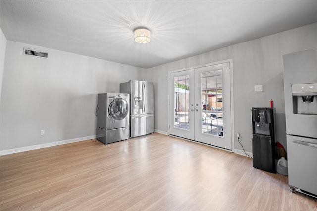 laundry area with french doors, washer / clothes dryer, and light wood-type flooring