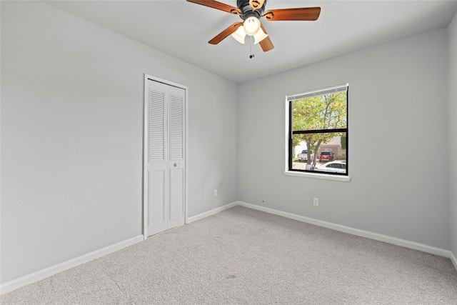 carpeted spare room with ceiling fan