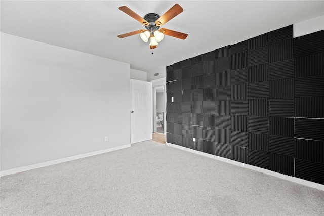 carpeted spare room with ceiling fan