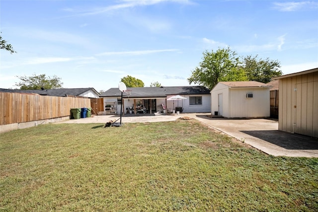 back of house featuring a yard, a patio area, and a storage unit