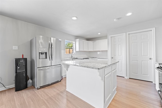 kitchen with sink, stainless steel appliances, a center island, and white cabinets