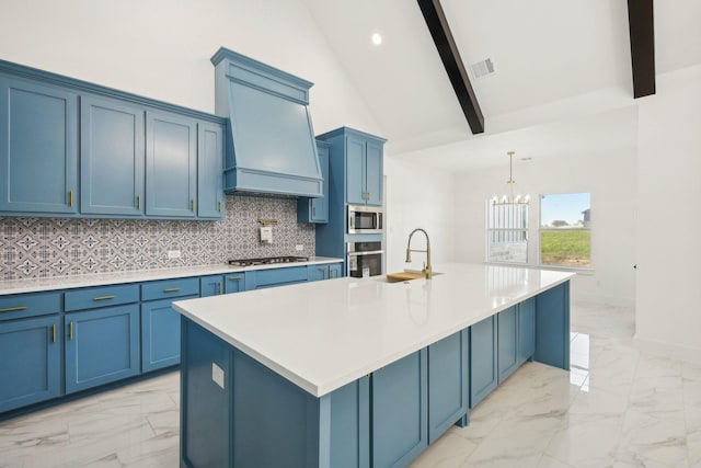 kitchen featuring a large island with sink, appliances with stainless steel finishes, custom range hood, and blue cabinets