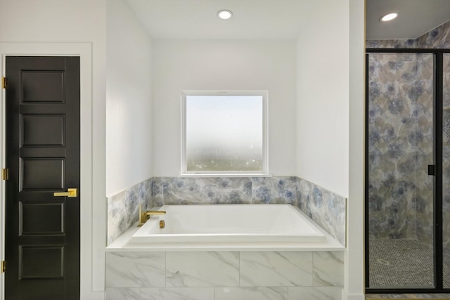 bathroom featuring shower with separate bathtub