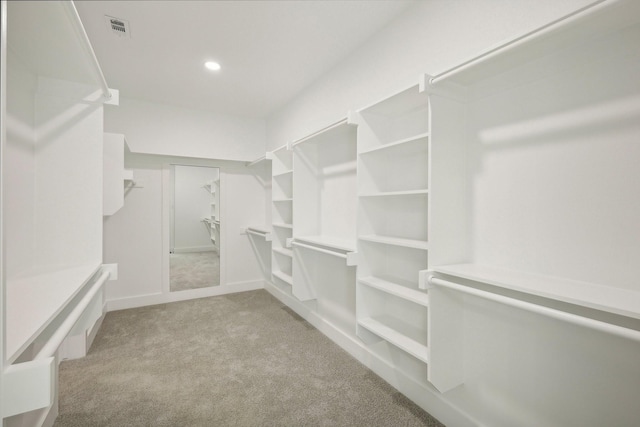 walk in closet featuring light colored carpet