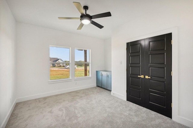 unfurnished bedroom with light colored carpet and ceiling fan