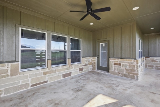 view of exterior entry with ceiling fan and a patio