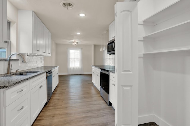 kitchen with white cabinets, sink, dark stone counters, and stainless steel appliances