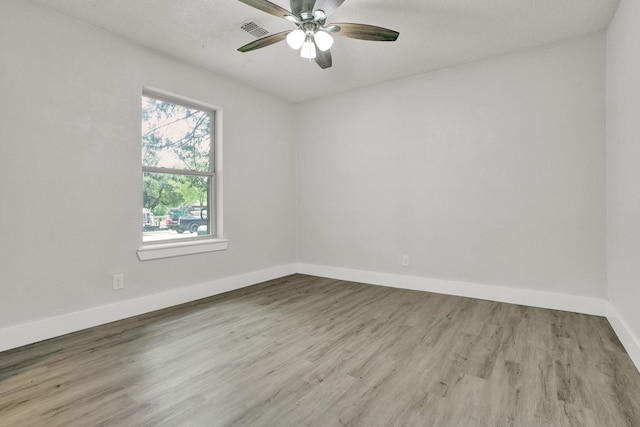 spare room with ceiling fan and light wood-type flooring