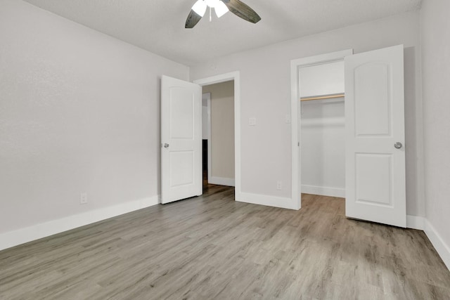 unfurnished bedroom with a textured ceiling, light wood-type flooring, a closet, and ceiling fan