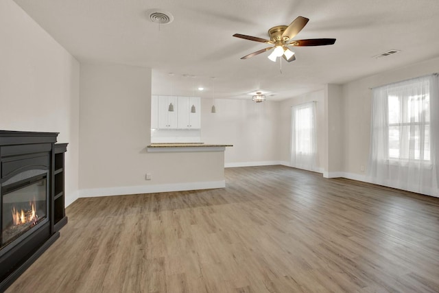 unfurnished living room with hardwood / wood-style floors and ceiling fan