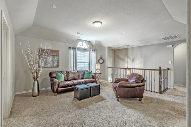 living room featuring vaulted ceiling, carpet, and a textured ceiling