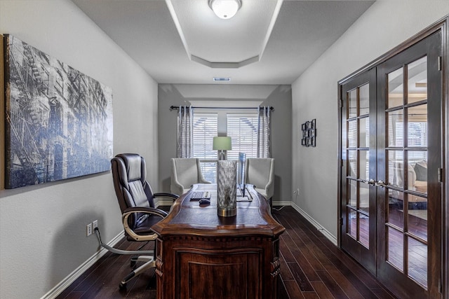 office space featuring a raised ceiling, dark hardwood / wood-style flooring, and french doors