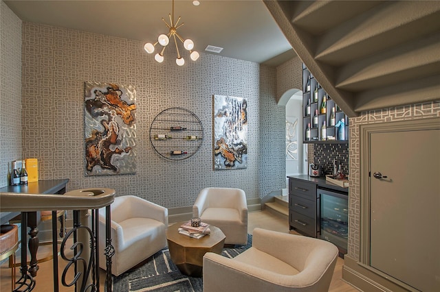 sitting room featuring beverage cooler, bar area, and light hardwood / wood-style flooring