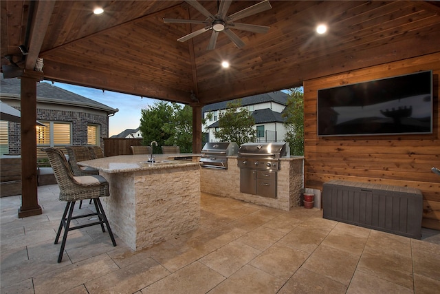 view of patio / terrace featuring a grill, area for grilling, ceiling fan, and a wet bar