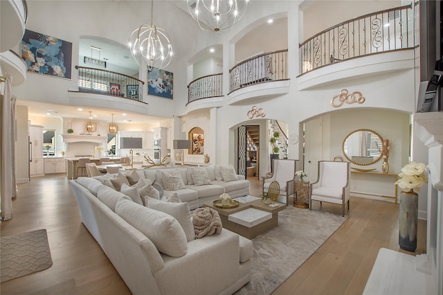 living room with an inviting chandelier and light hardwood / wood-style flooring