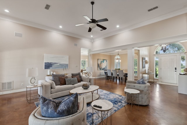 living room with ceiling fan with notable chandelier, a wealth of natural light, and crown molding