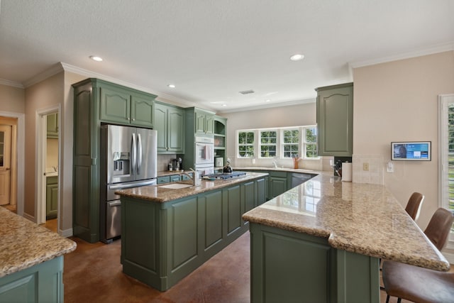 kitchen featuring a center island, stainless steel appliances, kitchen peninsula, a breakfast bar, and green cabinetry