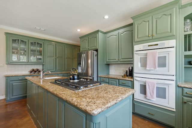 kitchen with ornamental molding, stainless steel appliances, and an island with sink