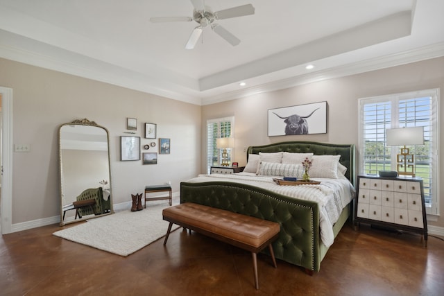 bedroom with ceiling fan, multiple windows, and a tray ceiling