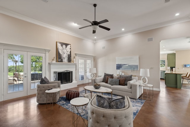 living room with a brick fireplace, ceiling fan, crown molding, and french doors