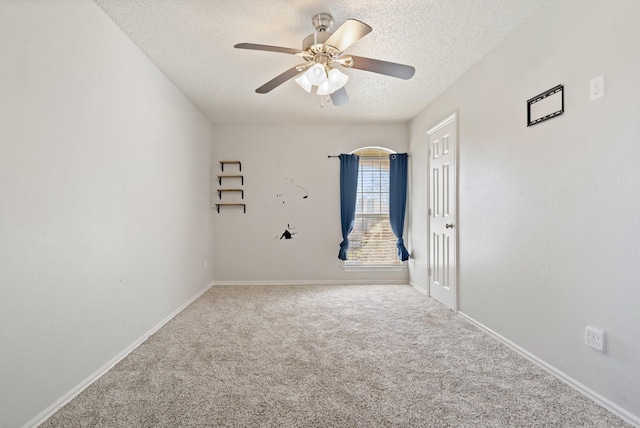 carpeted spare room featuring ceiling fan and a textured ceiling