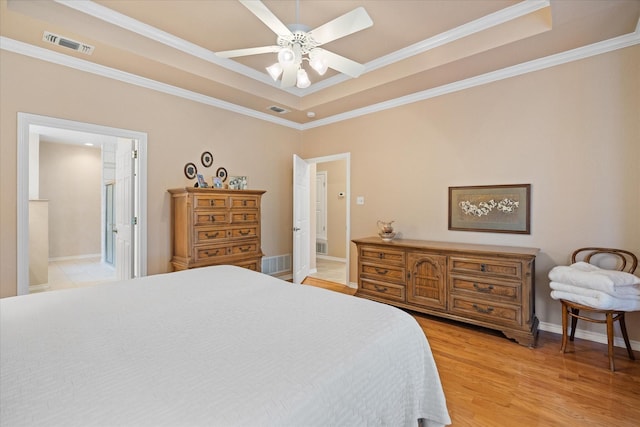 bedroom featuring a raised ceiling, ceiling fan, crown molding, and ensuite bathroom