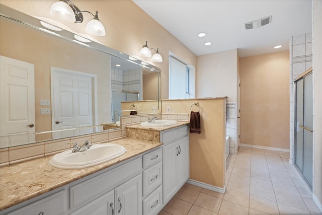 bathroom featuring shower with separate bathtub, vanity, and tile patterned floors