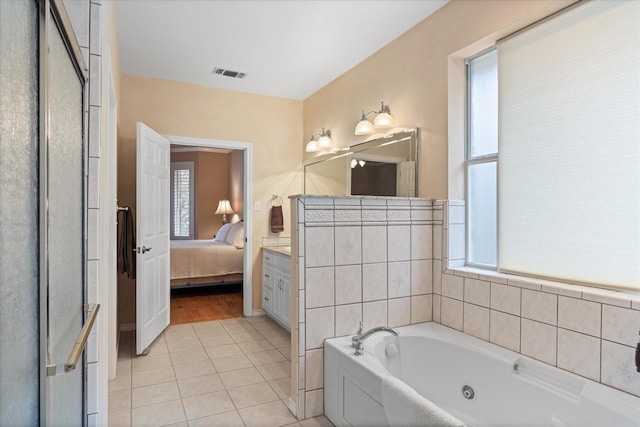 bathroom with tile patterned floors, a tub to relax in, and vanity