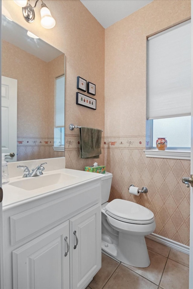 bathroom featuring tile patterned floors, vanity, toilet, and tile walls